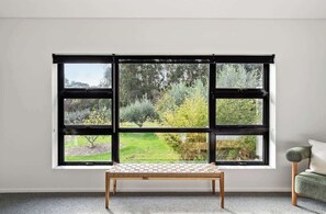 Pause by the window seat in the primary bedroom and take in views across the orchard and surrounding greenery as natural light fills the space.