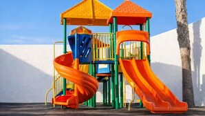 Une aire de jeux avec un toboggan et des structures d’escalade.
