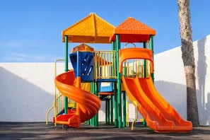 A playground with a slide and climbing structures. - Oasis Duna-Pool Side View Apartment-Corralejo (Corralejo)
