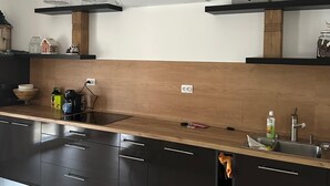 A modern kitchen with dark cabinets, a wooden countertop, a built-in stove, and a wall-mounted air conditioner. - La Luna 2
Modern Haus im Stadzentrum (Zaječar)