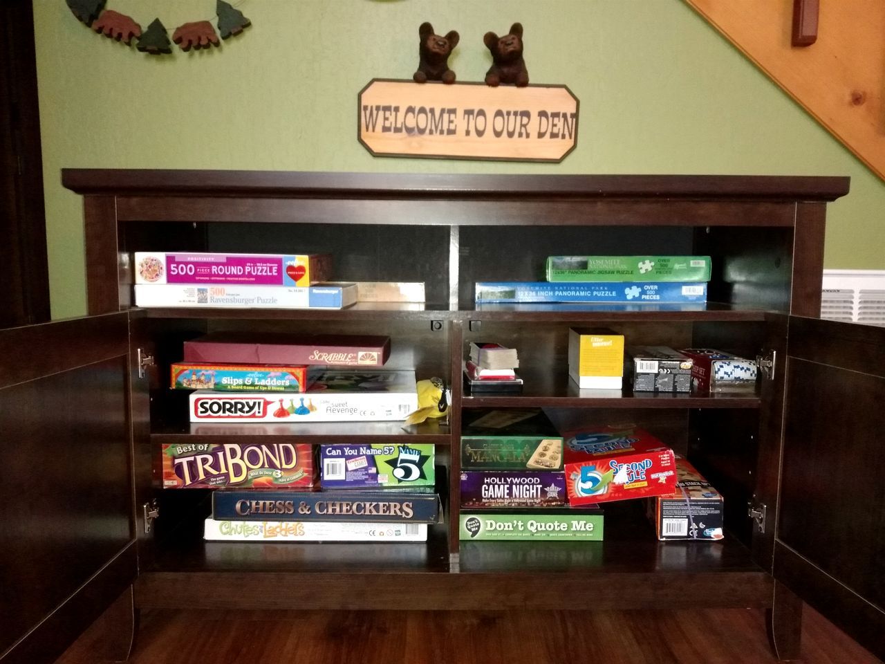 A wooden display case with various board games and puzzles.