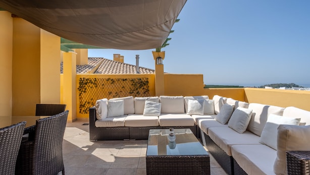 A sunlit outdoor seating area with a sofa, chairs, and a table, overlooking a coastal view. - Adb352 - Penthouse Walk to Beach & Town (Marbella)