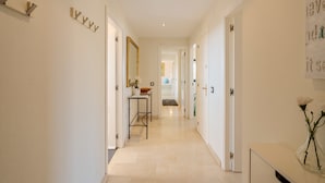 A hallway with a mirror, a vase with flowers, and a door with a gold handle. - Adb352 - Penthouse Walk to Beach & Town (Marbella)