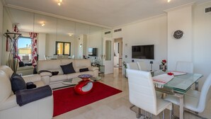 A modern living room with a sofa, coffee table, and dining area. - Adb352 - Penthouse Walk to Beach & Town (Marbella)