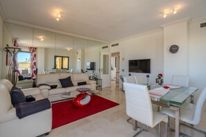 Ein modernes Wohnzimmer mit Sofa, Couchtisch und Essbereich.