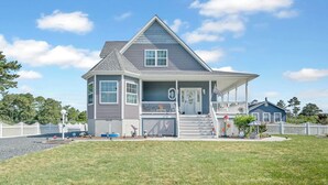 A two-story house with a porch, a covered front entrance, and a small front yard.