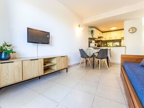 A modern apartment with a TV, dining area, kitchenette, and a bed. - Apartment Royal by Interhome (Salou)