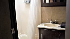 Un baño con una bañera blanca, un lavabo doble y una toalla sobre la encimera.