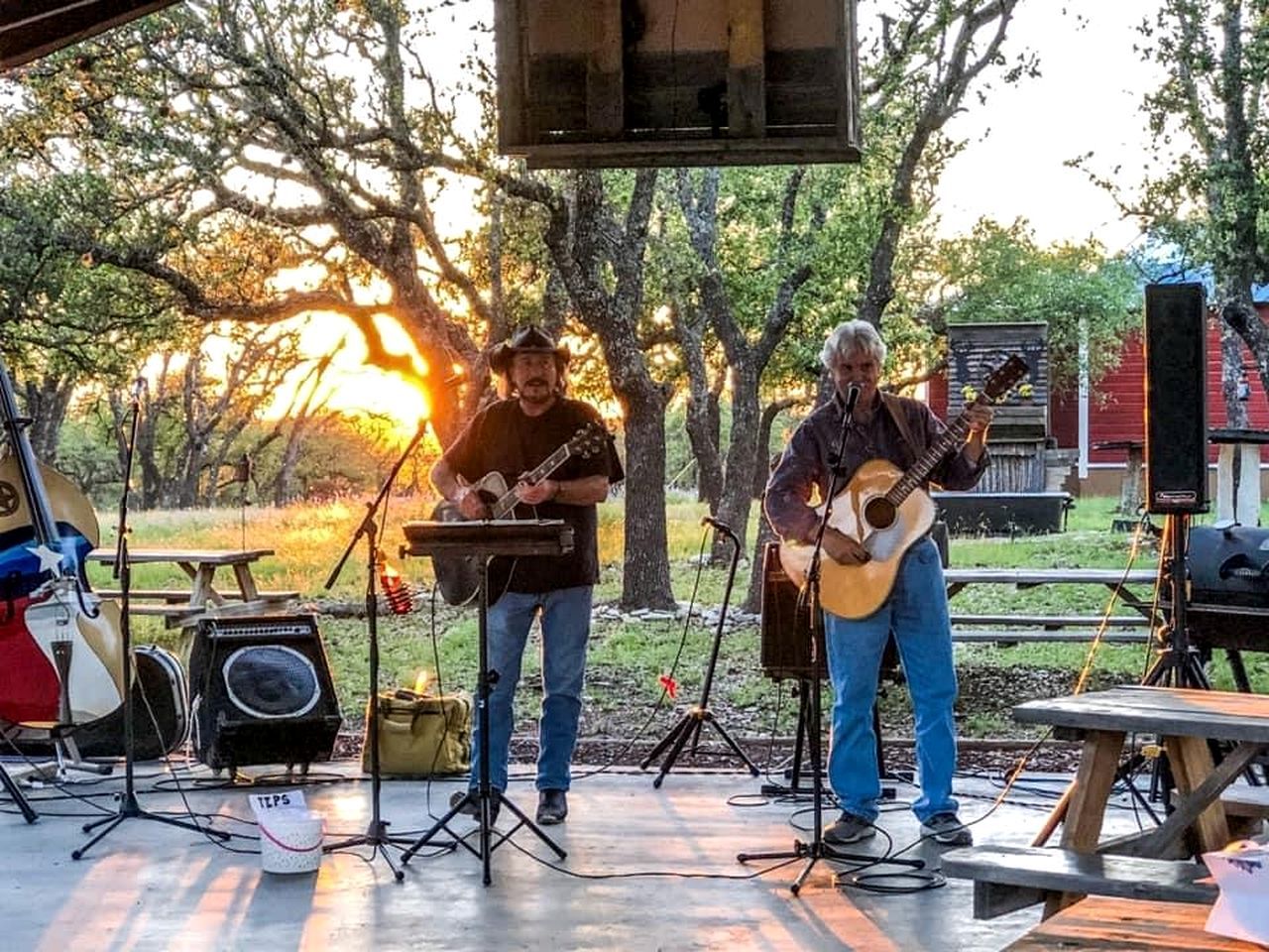 An outdoor music performance with a stage, musical instruments, and a microphone stand.