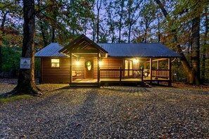 Eine rustikale Holzhütte mit Veranda, einer Holztür und einem Schild mit der Aufschrift 'Sweet Escape'.