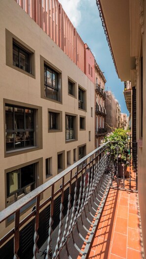 Eine schmale Stadtstraße mit Häusern, die große Fenster und Balkone haben.