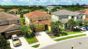A residential area with houses, a driveway, and a parked car. - 6BR Pool Home Near Disney at Solterra (Davenport)