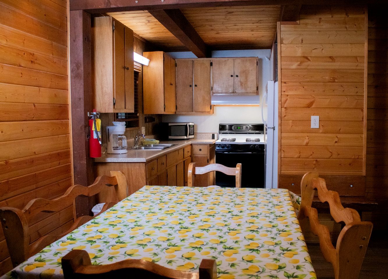 Una cocina compacta con gabinetes de madera, un microondas y una estufa.