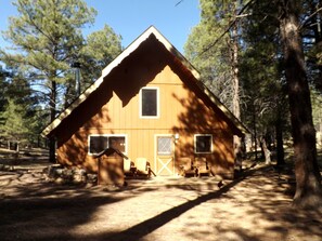 A wooden cabin with a gabled roof, a front door, and two windows. - Duplex Cabin with Spacious Interior Great for Groups in Arizona (Flagstaff)