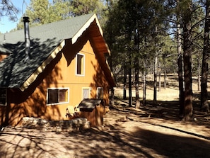 A cabin with a sloped roof, a chimney, and a small porch with a bench. - Duplex Cabin with Spacious Interior Great for Groups in Arizona (Flagstaff)