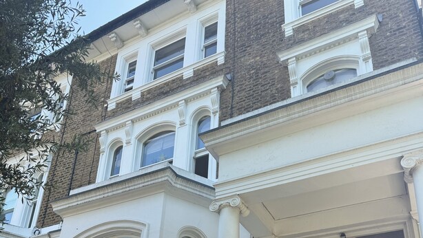A multi-story building with a grand entrance, large windows, and a prominent door marked with the number 7. - Light, airy, great location, newly decorated and furnished. Great views. (London)