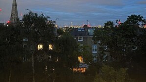 A cityscape at dusk with a prominent church spire, residential buildings, and a distant skyline. - Light, airy, great location, newly decorated and furnished. Great views. (London)