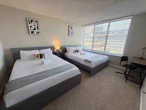 A hotel room with two beds, a desk, and a window with blinds. - Arlington Gem Stylish Apt with Pool  (Arlington)