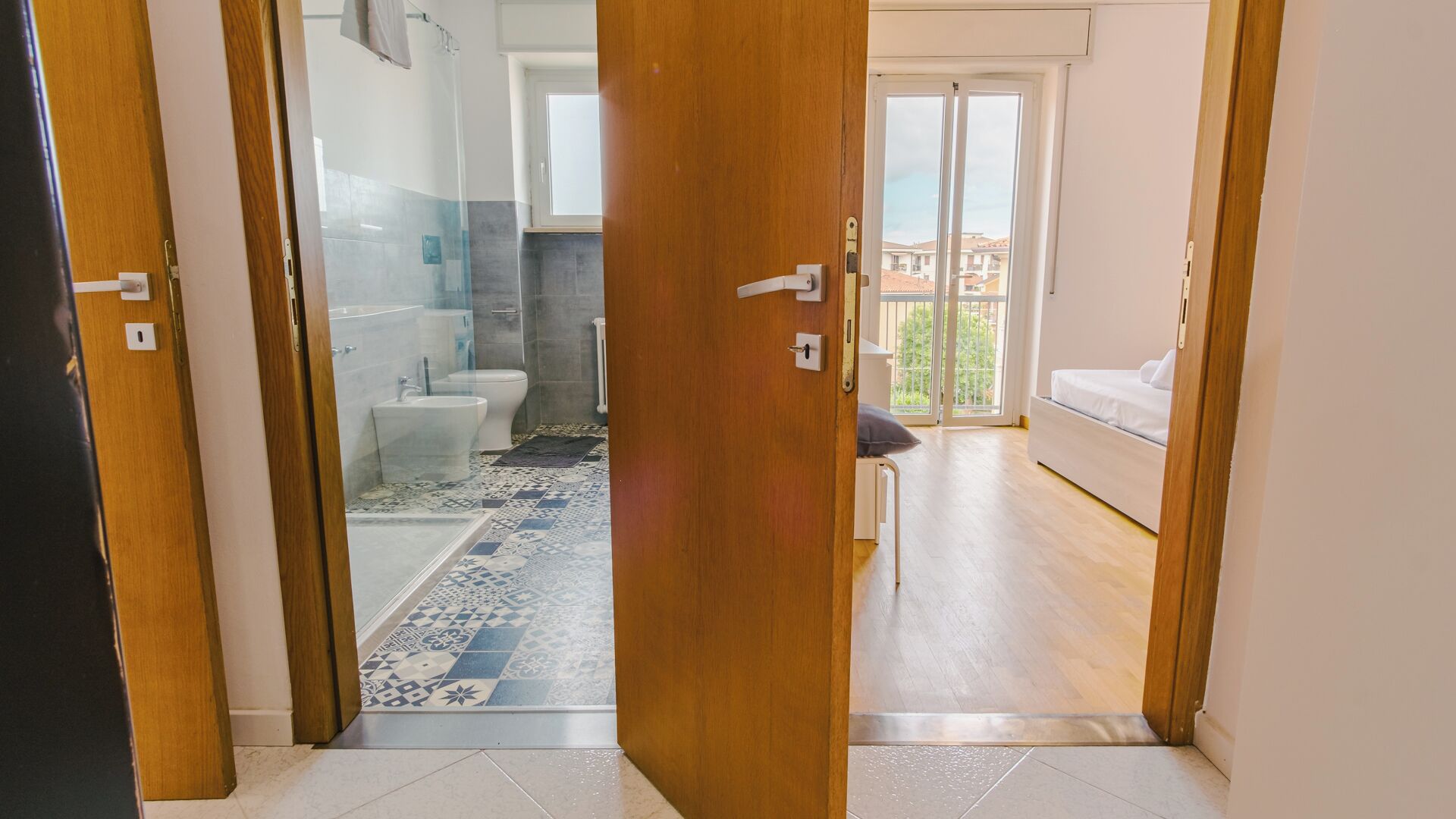 A room with a shower, toilet, and a bed.