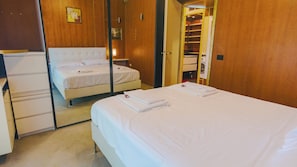 Ein Hotelzimmer mit zwei Betten, einem Schrank und einem Spiegel.