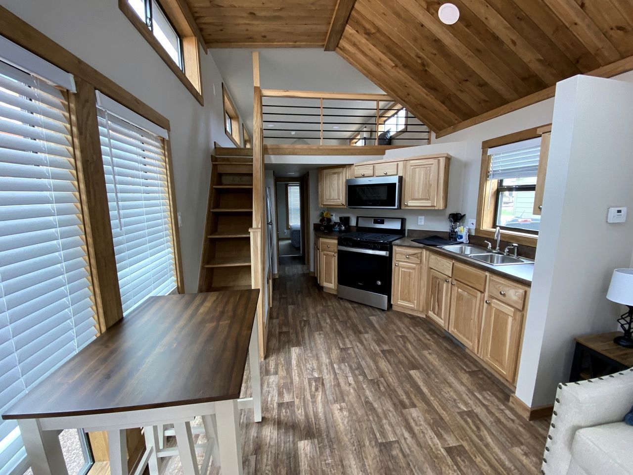 Une cuisine compacte avec des meubles en bois, un four encastré et un coin repas équipé d’une banquette.