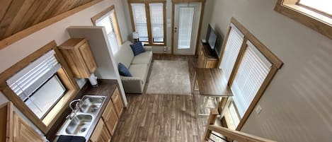 A compact kitchen with wooden cabinetry, a built-in sink, and a dining area with a table and chairs.