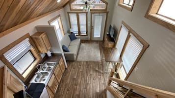 Une cuisine compacte dotée de meubles en bois, d’un évier encastré et d’un coin repas avec une table et des chaises.