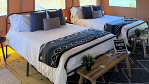 A tented accommodation with two beds, a hanging light fixture, and a sign on the bench. - Spacious Double Safari Tent with Private Fire Pit Near Anna Maria Island in Bradenton, Florida (Bradenton)