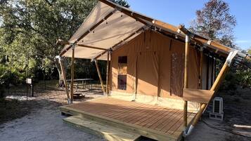 A tent-like structure with a wooden deck and a canopy.
