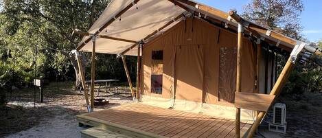 A tent-like structure with a wooden deck and a canopy.