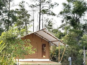 Eine kleine, einstöckige Hütte mit Satteldach, umgeben von dichtem Wald.