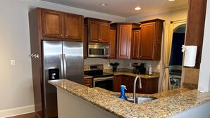 A kitchen with granite countertops, stainless steel appliances, wooden cabinets, and a built-in microwave. - Welcome to Atlanta: Old-Fashion Charm Meets Modern Retreat Near Airport (Atlanta)