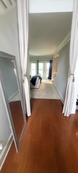 Ein Zimmer mit einem großen Spiegel, einem Bett, einem Schrank und einer Tür.