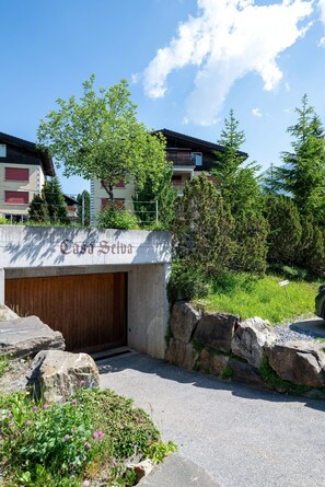 A building with a concrete entrance, a wooden door, and a sign reading 'Casa Selva.'