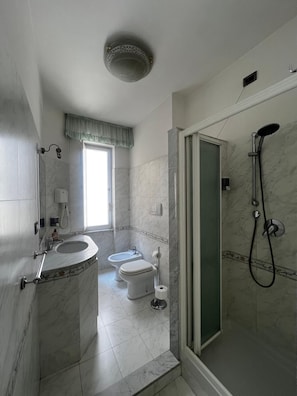 A bathroom with a shower, toilet, bidet, and sink. - Accommodation in Appia Nuova (Roma)