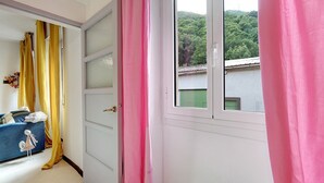 A room with a window, a door, and a view of a green landscape. - Varazze Mare Apartment with Two Bathrooms and Courtyard (Varazze)