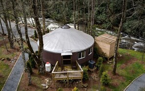 A yurt with a circular roof, a wooden deck, and a small porch. - Heavenly Yurt with Modern Interior in Topton, North Carolina (Topton)