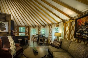 A tent-style room with a wooden ceiling, a bar area, seating, and a painting on the wall. - Heavenly Yurt with Modern Interior in Topton, North Carolina (Topton)