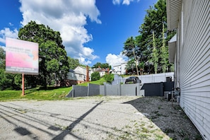 A residential area with houses, a gravel driveway, and a signboard.