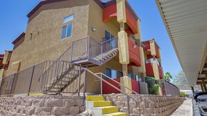 A multi-story building with a staircase leading to the entrance, a balcony, and a covered area. - Golf & Gamble! Mesquite Condo w/ Pool Access (Mesquite)