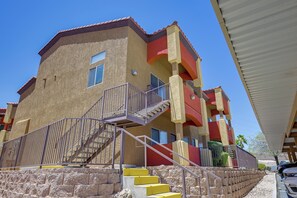 A multi-story building with a staircase leading to the entrance, a balcony, and a covered area. - Golf & Gamble! Mesquite Condo w/ Pool Access (Mesquite)