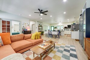 A living room with a sofa, a coffee table, and a dining area with chairs and a table. - Deck & Fire Pit! Mtn Escape, 12 Mi to Asheville (Leicester)