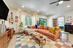 A living room with a sofa, coffee table, and a television. - Deck & Fire Pit! Mtn Escape, 12 Mi to Asheville (Leicester)