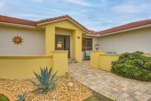 A yellow building with a tiled roof, a paved patio, and a small garden with an agave plant. - Canal-front Gem w/ Boat Dock! Punta Gorda Getaway (Punta Gorda)