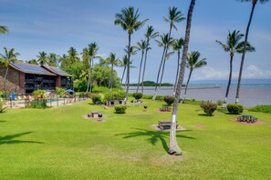 A resort with a pool, palm trees, and a view of the water.