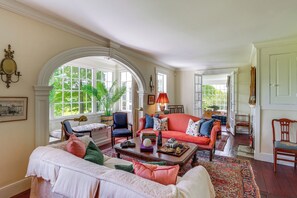 A spacious living room with a large window, a fireplace, and a cozy seating area.