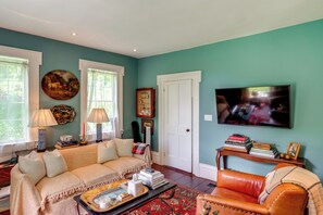 A living room with a sofa, a coffee table, a television, and a bookshelf.