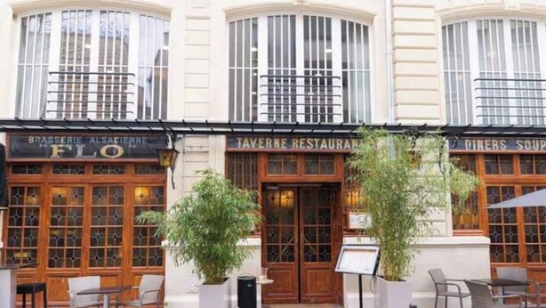 Ein Gebäude mit drei Schaufenstern: 'Brasserie Alsacienne Flo', 'Taverne Restaurant' und 'Diners Soup'.