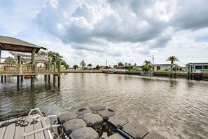 A dock with hexagonal seating, a covered area, and a calm water body with buildings in the background. - Boat Dock Access! Pet-friendly Studio in Hudson (Hudson)