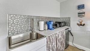 A kitchen with a patterned backsplash, stainless steel sink, and various appliances. - Boat Dock Access! Pet-friendly Studio in Hudson (Hudson)